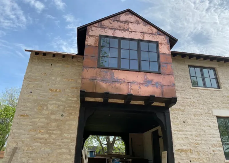 Copper metal panel facade on a stone building for Skylight Installation in Alvin